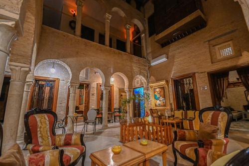 a lobby with chairs and tables in a building at Palais Harran in Kairouan