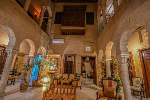 a room with chairs and tables in a building at Palais Harran in Kairouan