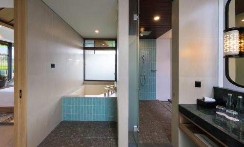 a bathroom with a tub and a sink at Hotel Santika Premiere Garut in Garut