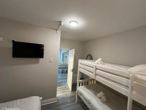 a bedroom with two bunk beds and a flat screen tv at Shamrock Inn in Cork