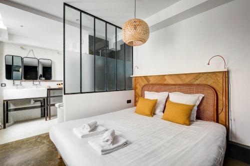 une chambre avec un grand lit avec des oreillers jaunes dans l'établissement Stylish and sunny 7BD with garden for 17 guests!, à Paris