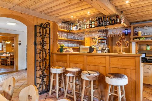a kitchen with wooden cabinets and bar stools at Gasthaus Mamoosen in Penning