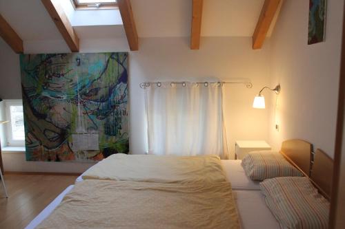 a bedroom with a bed and a painting on the wall at Sunflower House in Bolzano