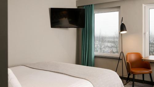 a bedroom with a bed and a television on the wall at Marine Hotel Ballycastle in Ballycastle