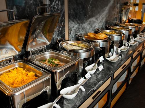 a buffet line with many pots and pans of food at Ramada Sukhumvit Soi Eleven in Bangkok