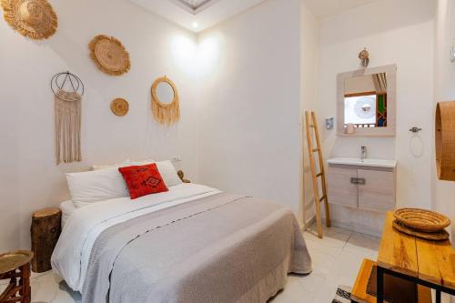 une chambre avec un lit avec un oreiller rouge dessus dans l'établissement RIAD Miel & Une Nuit, à Marrakech