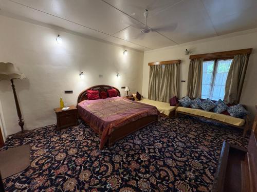 una camera da letto con un letto grande e un divano di Heritage Mansion a Srinagar