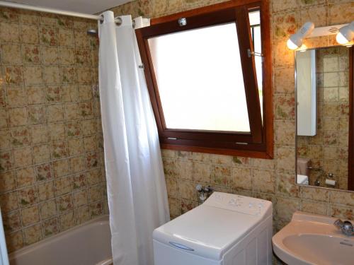 une salle de bain avec un lavabo et des toilettes et une fenêtre dans l'établissement Casa Vacacional Tranquila con Piscina, Jardín y Cerca de la Playa en L'Estartit - ES-323-29, à L'Estartit