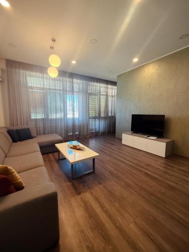 een woonkamer met een bank en een tv bij Cherry Tree House in Jerevan