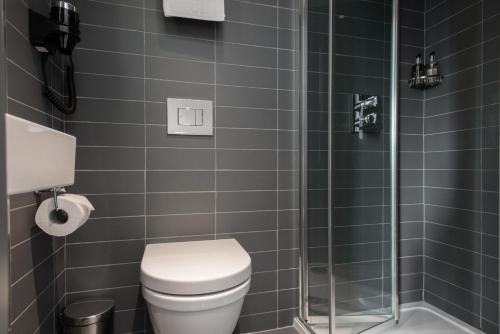a bathroom with a toilet and a glass shower at Mowbray Court Hotel in London