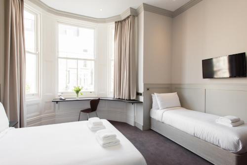 um quarto de hotel com duas camas e uma televisão em Mowbray Court Hotel em Londres