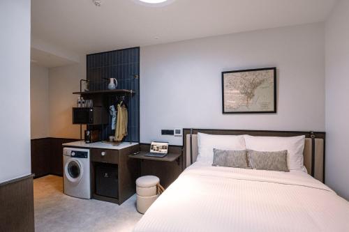 1 dormitorio con 1 cama y lavadora en Coliwoo Hotel Kampong Glam - CoLiving, en Singapur