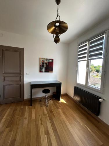 a living room with a desk and a window at Gîte du Camp de César - WIFI - 8 personnes in Bracquemont