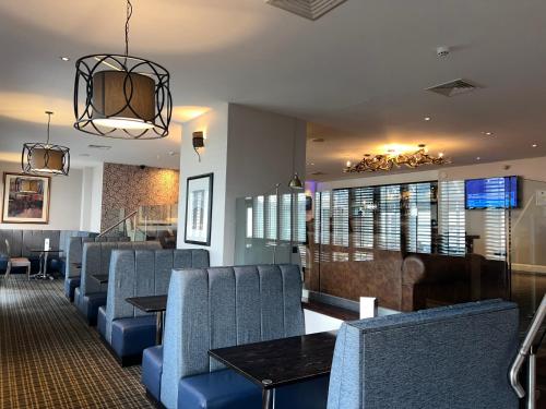 a dining room with chairs and tables and a chandelier at Barony Castle Hotel in Peebles