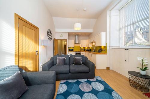 a living room with a couch and a kitchen at Church House in Angus