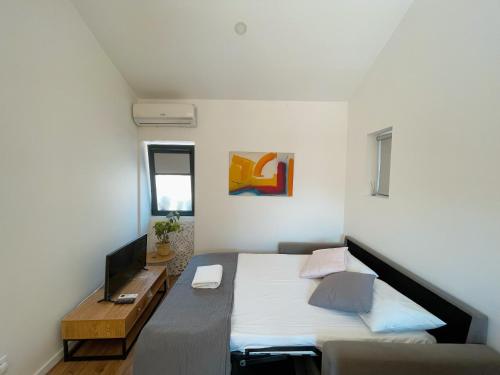 a bedroom with a bed with a desk and a television at 9min Metro to Downtown - couples&kids - free parking in Porto