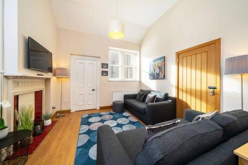 a living room with a couch and a tv at Church House in Angus