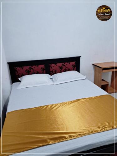 a bed with a yellow blanket on top of it at Chico Holidey Resort in Anuradhapura
