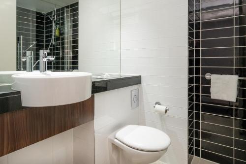 a bathroom with a white toilet and a sink at The Duxford Hotel Cambridge South M11 Jct 10 in Cambridge
