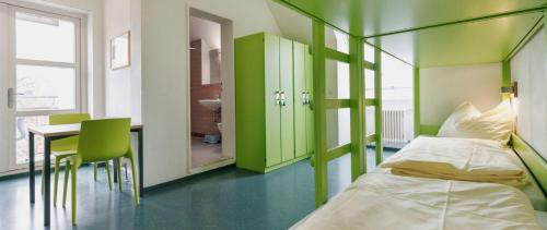 a hospital room with two beds and a table at HI Youth Hostel Lindau in Lindau