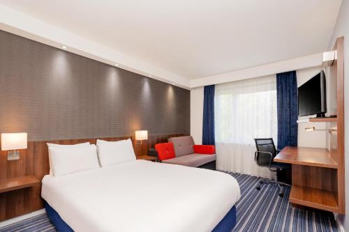 a hotel room with a large bed and a desk at The Duxford Hotel Cambridge South M11 Jct 10 in Cambridge