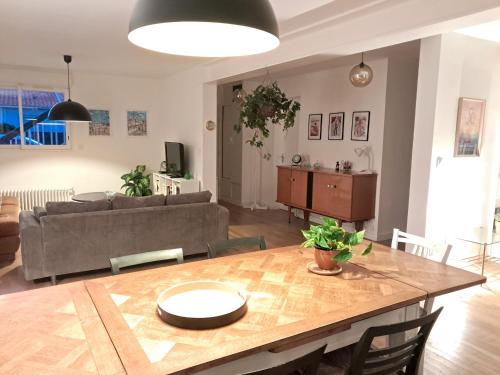 a living room with a table and a couch at Loue maison 10 couchages à La Rochelle avec jardin, proche plage in La Rochelle