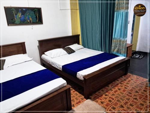 a bedroom with two beds and a window at Chico Holidey Resort in Anuradhapura