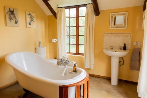 une salle de bain avec une grande baignoire et un lavabo dans l'établissement Waterberg Cottages, Private Game Reserve, à Vaalwater