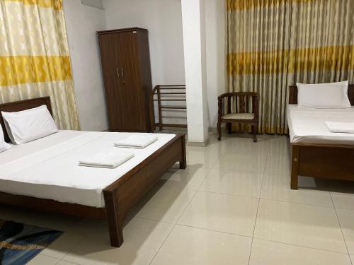 a room with two beds and a chair at Tenshin Residance. in Kandy