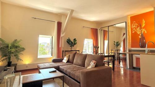 a living room with a couch and a table at Duplex - Air-conditioned - City Center in Villefranche-sur-Saône