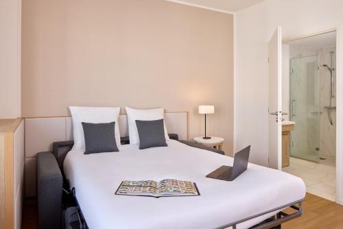 a bedroom with a bed with a laptop on it at Zenitude Hôtel Résidences Chessy in Chessy