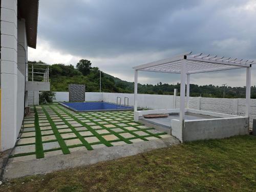 a backyard with a swimming pool and a pavilion at Rolling Hills in Nashik