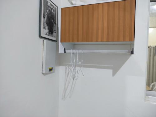 een keuken met een kast waaraan touwtjes hangen bij Casa próximo centro de eventos com ar condicionado in Fortaleza