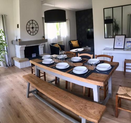 une salle à manger avec une table et des chaises et une cheminée dans l'établissement La Prairie - 4 chambres, parking, jardin, à Bures-sur-Yvette
