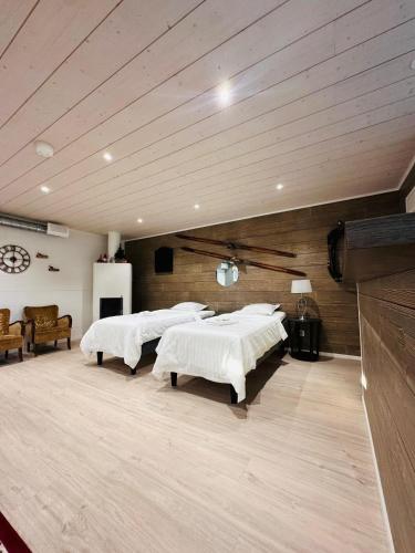 a room with four beds in a room with wooden ceilings at Alanko Lodge in Tornio