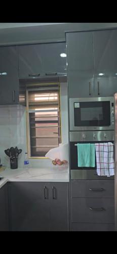 a kitchen with a microwave oven and a sink at Kim's Apartment in Agege