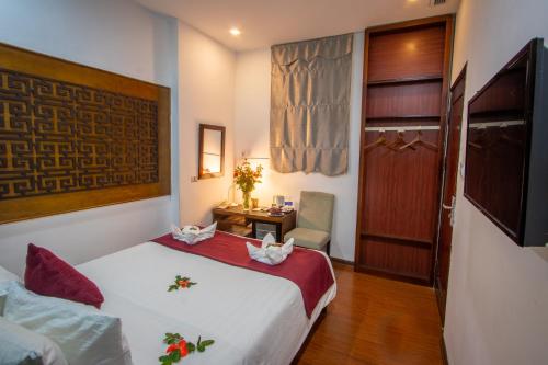 a hotel room with a bed and a desk and a television at NT Elysian hotel in Hanoi