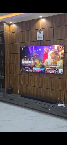 a large flat screen tv in a wooden wall at Kim's Apartment in Agege