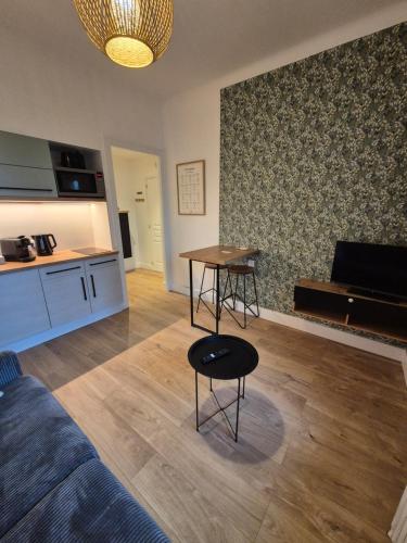 a living room with a table and a couch at Logement "L'Olivier" TREVOUX climatisé in Trévoux