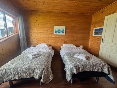 a room with two beds in a wooden cabin at Brekkestranda Fjordhotel in Brekke