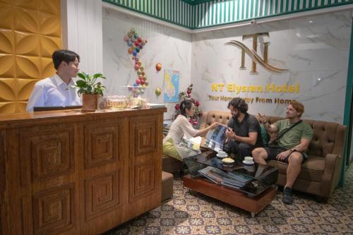 a group of people sitting on a couch in a room at NT Elysian hotel in Hanoi
