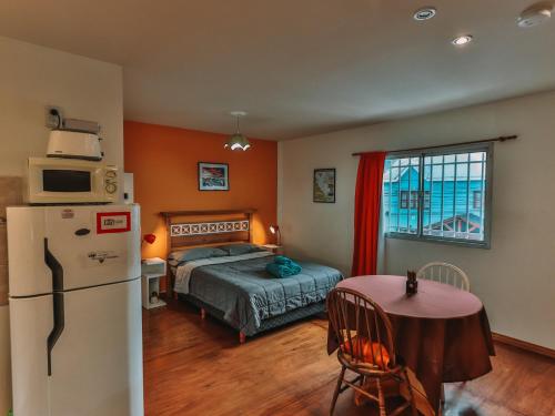 Un dormitorio con una cama, una mesa y un frigorífico. en Gala Austral, en Ushuaia
