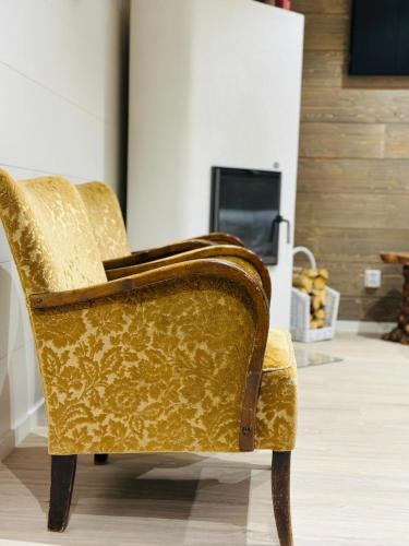 a gold chair in a room with a fireplace at Alanko Lodge in Tornio
