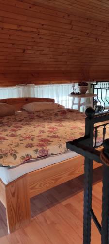 a bed in a bedroom with a wooden ceiling at Lavendel Apartman in Harkány