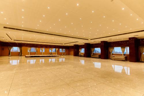 a large room with a dance floor with lights on the ceilings at Tania President Inn in Shirdi