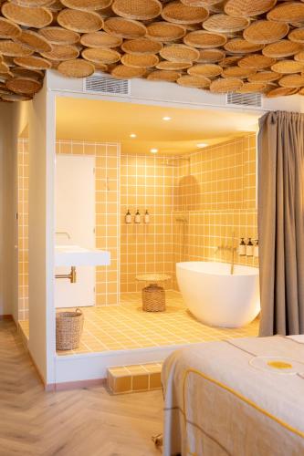 a bathroom with a tub and a sink at Hotel M Soleil - Montpellier Centre Saint Roch in Montpellier
