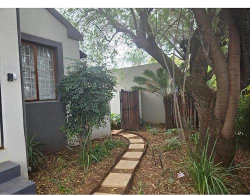 a house with a tree and a wooden door at The Chardonnay Inn in Centurion