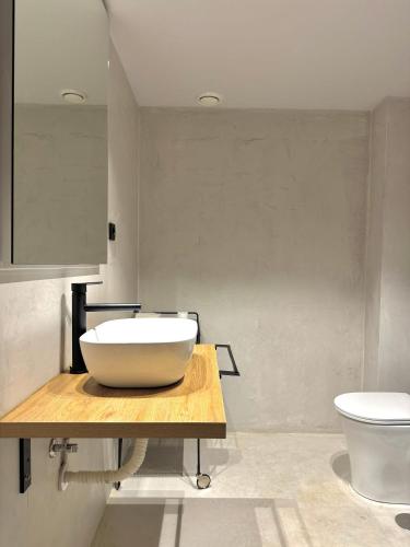 a bathroom with a bowl sink and a toilet at Pazo da Buzaca in Moraña