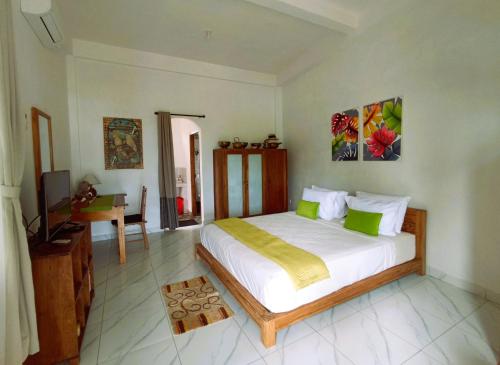 a bedroom with a large bed and a desk at Pondok Pisces Bungalows Balian Beach in Selemadeg