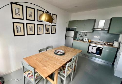 Una cocina con una mesa de madera y algunas sillas. en terzopiano urban loft, en Cagliari